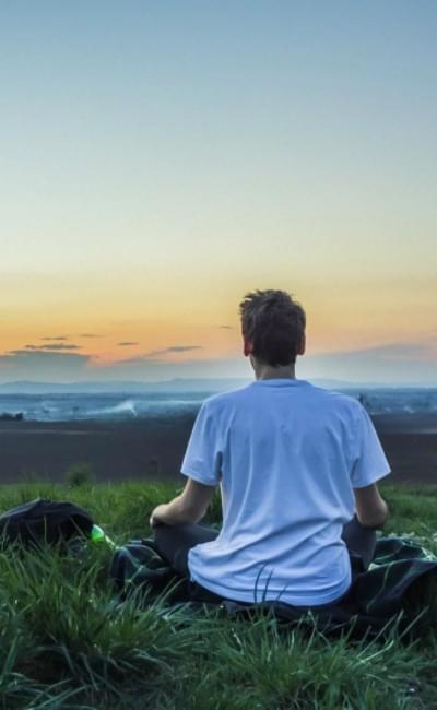 a man sitting quietly enjoying a sunrise